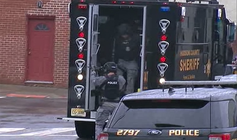 In this image taken from video, Hudson County Swat team officers arrive at the scene following reports of gunfire Tuesday, Dec. 10, 2019, in Jersey City, N.J. (WNYW FOX 5 via AP)