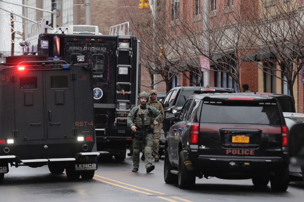 Police officers work nearby the scene following reports of gunfire, Tuesday, Dec. 10, 2019, in Jersey City, N.J. (AP Photo/Seth Wenig)