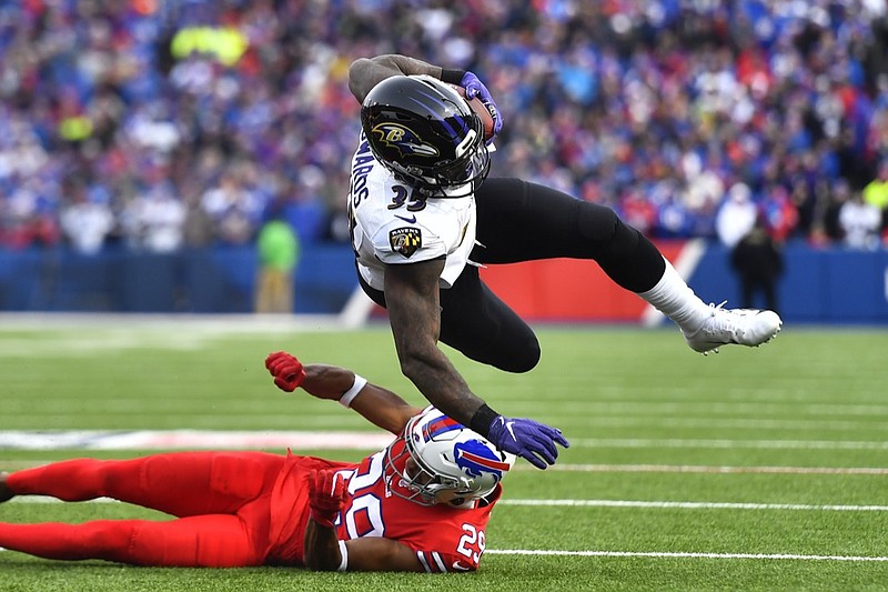 Baltimore Ravens running back Gus Edwards (35) is upend by Buffalo Bills cornerback Kevin Johnson (29) during the second half of an NFL football game in Orchard Park, N.Y., Sunday, Dec. 8, 2019. (AP Photo/Adrian Kraus)