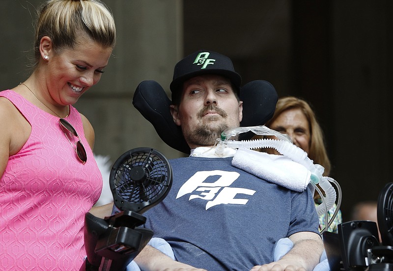In this Sept. 5, 2017, file photo, Pete Frates, right, who inspired the ice bucket challenge, looks at his wife Julie during a ceremony at City Hall in Boston by Boston Mayor Marty Walsh declaring the day the Pete Frates Day. Frates, who was stricken with amyotrophic lateral sclerosis, or ALS, died Monday, Dec. 9, 2019. He was 34. (AP Photo/Bill Sikes, File)