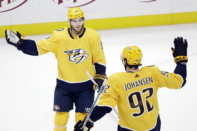 Nashville Predators center Calle Jarnkrok (19), of Sweden, celebrates with Ryan Johansen (92) after Jarnkrok scored an empty-net goal against the San Jose Sharks in the third period of an NHL hockey game Tuesday, Dec. 10, 2019, in Nashville, Tenn. The Predators won 3-1. (AP Photo/Mark Humphrey)