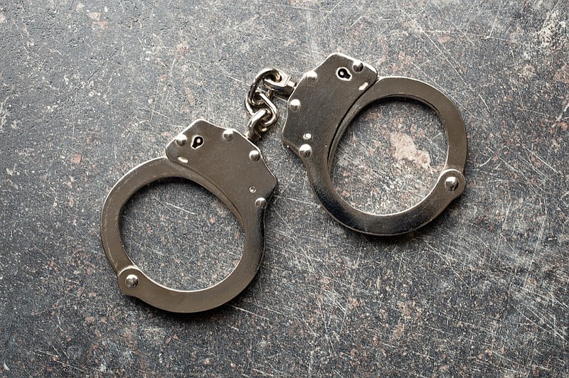 silver handcuffs on old crackled background arrest tile handcuffs tile police crime tile / Getty Images
