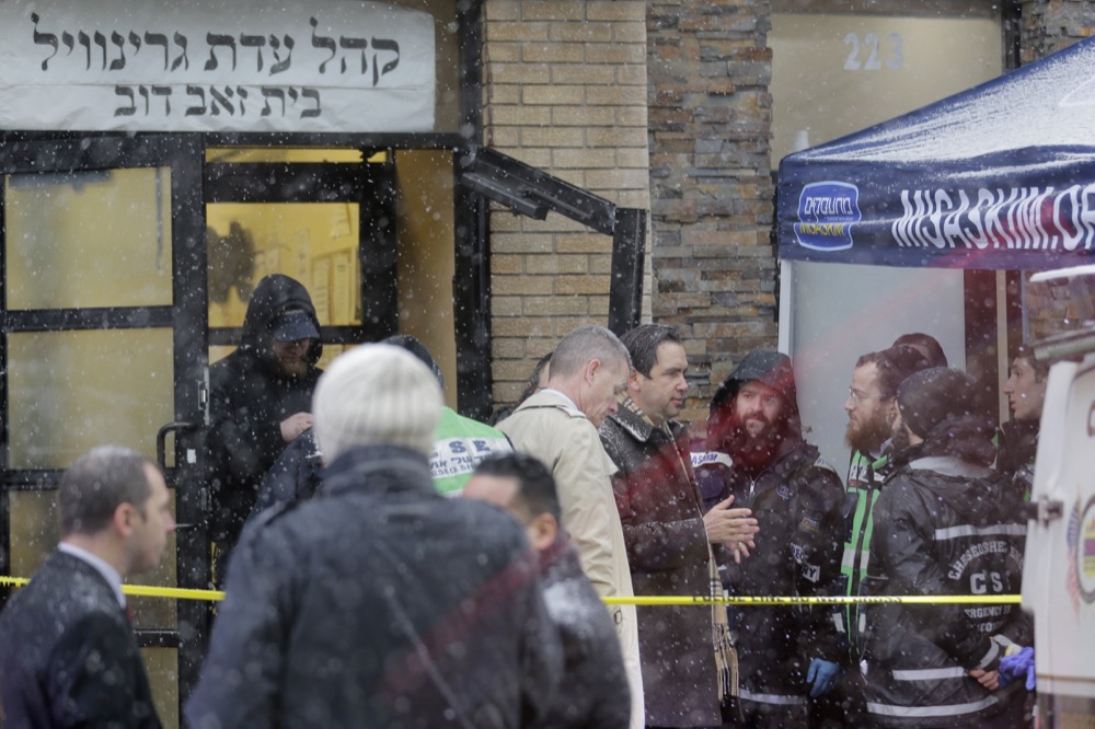 Jersey City’s mayor Steven Fulop, center right, talks with first responders at the scene of a shooting in Jersey City, N.J., Wednesday, Dec. 11, 2019. Fulop says gunmen targeted a kosher market during a shooting that killed six people Tuesday. (AP Photo/Seth Wenig)