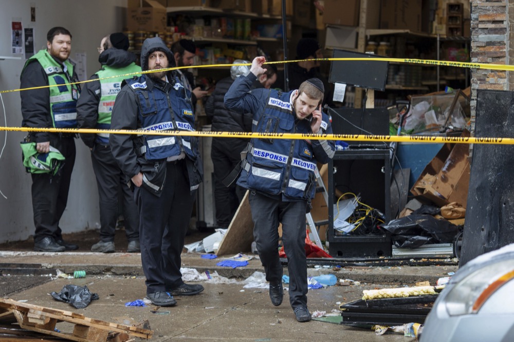 Responders work to clean up the scene of a shooting that left multiple dead at a kosher market on Dec. 11, 2018, in Jersey City, NJ. Police killed two gunmen who had earlier killed an officer at a cemetery in Jersey City. (AP Photo/Kevin Hagen).