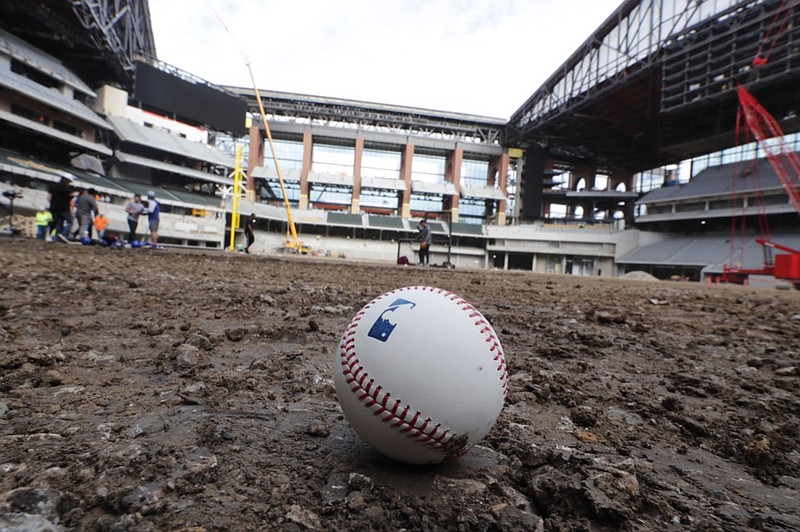 AP photo by LM Otero / A baseball lies on packed dirt after a short batting practice during a tour of the baseball field under construction at the Texas Rangers' new stadium on Dec. 4, 2019, in Arlington.