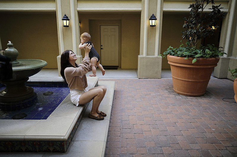 In this Aug. 24, 2018 file photo Keira Sumimoto plays with her daughter, in Irvine, Calif. Sumimoto, who used marijuana briefly for medical reasons while pregnant and breastfeeding, says her daughter is healthy and advanced for her age. More than three years after California voters approved broad legalized marijuana, a state panel is considering if the potent high-inducing chemical THC found in pot should be declared a risk to pregnant women and require warnings to consumers. (AP Photo/Gregory Bull,File)
