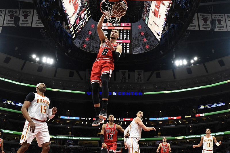 Chicago Bulls guard Zach LaVine dunks as the Atlanta Hawks' Vince Carter, left, looks on during the first half of Wednesday night's game in Chicago. LaVine scored 35 points despite sitting out the final 14 minutes as the Bulls cruised to a 136-102 victory. / AP photo by David Banks