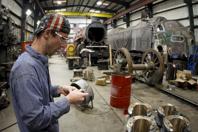 Staff Photo by Dan Henry - 3/18/13. Shane Meador, 35, project manager for TVRM, works on the 1911 Southern Railway 4501 / 2-8-2 Mikado type steam locomotive while at the Tennessee Valley Railroad Museum repair facility in East Chattanooga on Monday. Meador and his staff have been working on the large train for nearly two years and hope to have the project complete by late 2013 / early 2014.