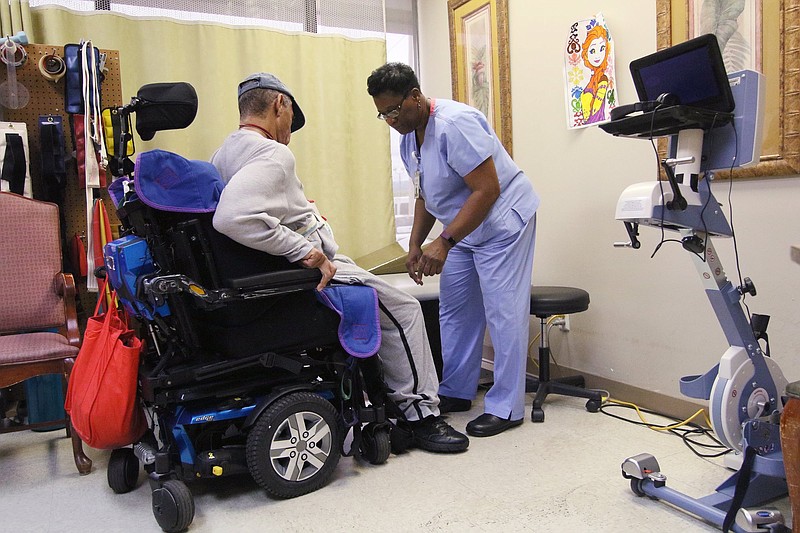 Jeffery Henson is assisted out of his wheelchair by Elouise Busby, a physical therapist at Alexian Brothers PACE, in a therapy room at Alexian Brothers PACE Tuesday, July 23, 2019 in Chattanooga, Tennessee. Before getting assistance from PACE, Henson would call 911 up to 85 times in a month to get help with all aspects of his life, from needing medical help to retrieving a television remote control.