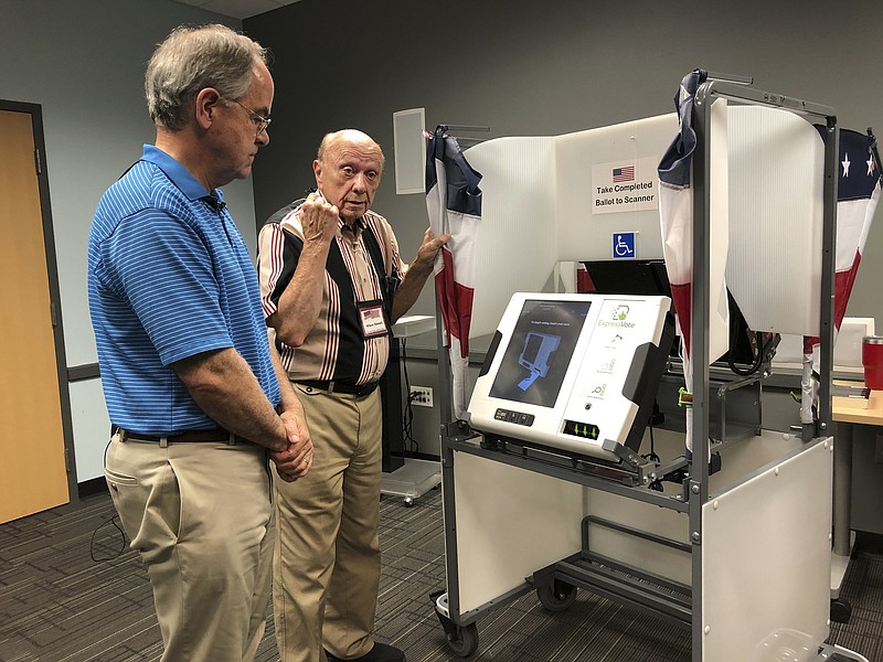 In this June 7, 2019 file photo U.S. Rep. Jim Cooper, left, a Nashville Democrat, checks out Davidson County's new voting equipment at the Green Hills Branch of the Nashville Public Library in Nashville, Tenn. A second big county in Tennessee won't have paper-trail producing voting equipment that experts consider crucial for election integrity in place by the March 3 presidential primary. Knox County — anchored by Knoxville — is eyeing a change from fully electronic machines to paper ballots that are filled out by hand then scanned, but they won't be functioning until state and federal elections in August 2020, county elections administrator Clifford Rodgers said Tuesday, Dec. 10, 2019. (AP Photo/Jonathan Mattise, file)