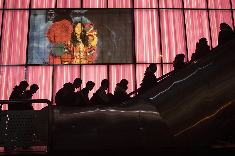 Shoppers at a retail district pass by an American lingerie company Victoria's Secrets store in Beijing on Friday, Dec. 13, 2019. China deputy trade envoy says China, U.S. have reached trade deal, will reduce punitive tariffs on each other's goods. (AP Photo/Ng Han Guan)