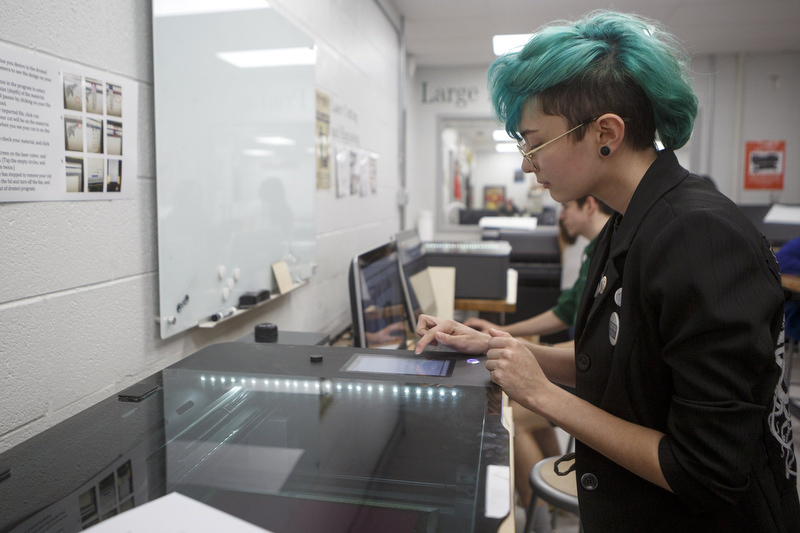 Staff photo by C.B. Schmelter / Ollie Allen uses a laser cutter inside the Volkswagen eLab at Chattanooga Center for Creative Arts on Tuesday, Dec. 10, 2019 in Chattanooga, Tenn.