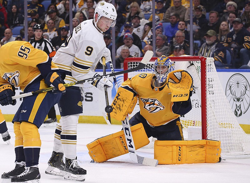 Buffalo Sabres forward Jack Eichel (9) tips the puck in front of Nashville Predators goalie Juuse Saros during the third period of Thursday night's game in Buffalo, N.Y. / AP Photo by Jeffrey T. Barnes