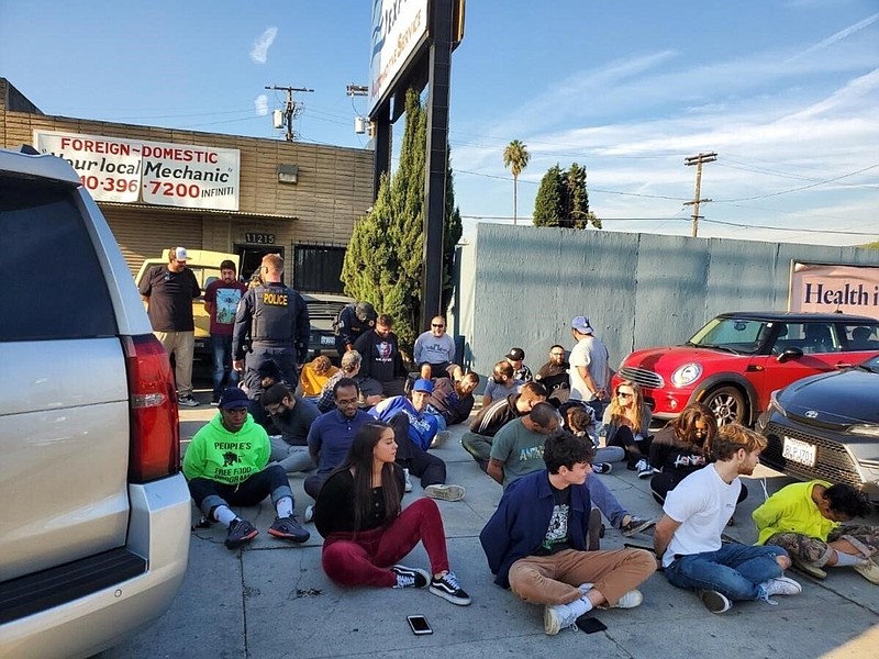 This Thursday, Dec,. 12, 2019 photo provided by the Department of Consumer Affairs shows suspects from Save Greens Cannabis dispensary being taken into custody by law enforcement for operating without a state license in Los Angeles. California regulators mounted two-dozen raids against illegal marijuana retailers in Los Angeles this week, the largest crackdown to date against the city's thriving illicit pot market, officials announced Friday, Dec. 13, 2019. (Megan Kiefer/Department of Consumer Affairs via AP)


