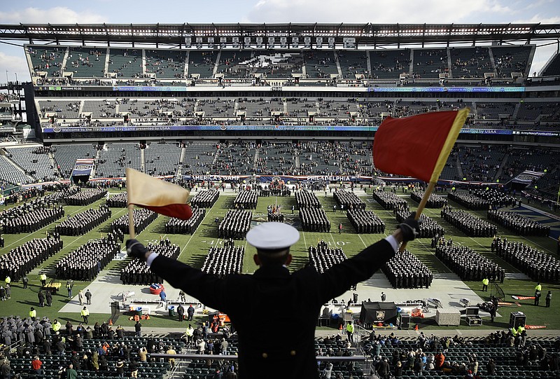Navy Midshipman Frey Pankratz signals to his classmates as they march onto the field before last year's football game against Army in Philadelphia. Navy leads the series 60-52-7 going into Saturday's game in Philadelphia. / AP photo by Matt Rourke