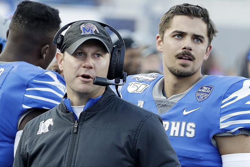 Ryan Silverfield, left, watches a replay on the scoreboard with Memphis quarterback Brady White during the AAC title game against visiting Cincinnati last Saturday. Silverfield, an assistant to Mike Norvell the past four seasons and the program's interim leader after Norvell left for Florida State last Sunday, was named head coach of the Tigers on Friday. / AP photo by Mark Humphrey