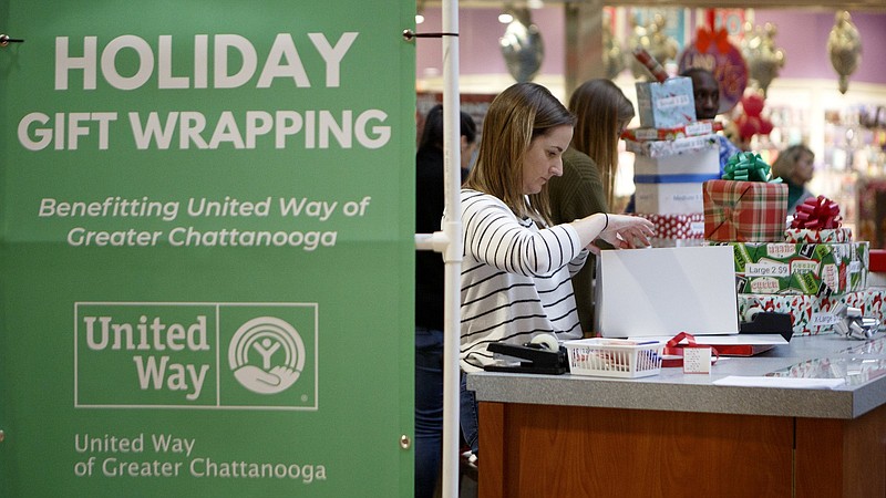 Staff photo by C.B. Schmelter / Director of Women United and Community Engagement Mary Kathryn Levy works on wrapping a present at the United Way of Greater Chattanooga gift wrapping booth outside of H&M at Hamilton Place mall on Friday, Dec. 13, 2019, in Chattanooga, Tenn. The United Way has two booths, one on each level of the mall, and will be wrapping presents until Dec. 24. Donations are suggested with prices varying depending on the size of the box, and they benefit United Way member agencies including the Neediest Cases Fund.