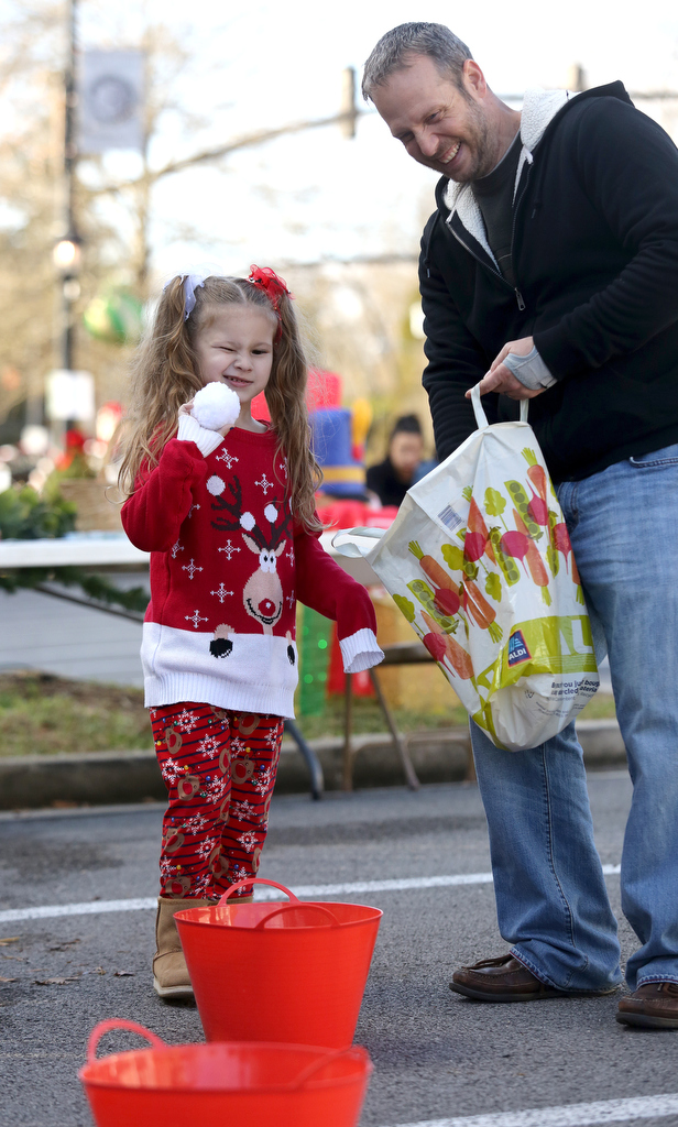 Staff photo by Erin O. Smith / Avalon Lugo, 5, plays snowball toss as Jason Gephart with Mt. View Church of Christ looks on during the Christmas in the Streets Block Party Saturday, December 14, 2019 in Chickamauga, Georgia. There were games, pictures with Santa and Mrs. Claus, the Great Elf Hunt, a parade and a movie in the street.