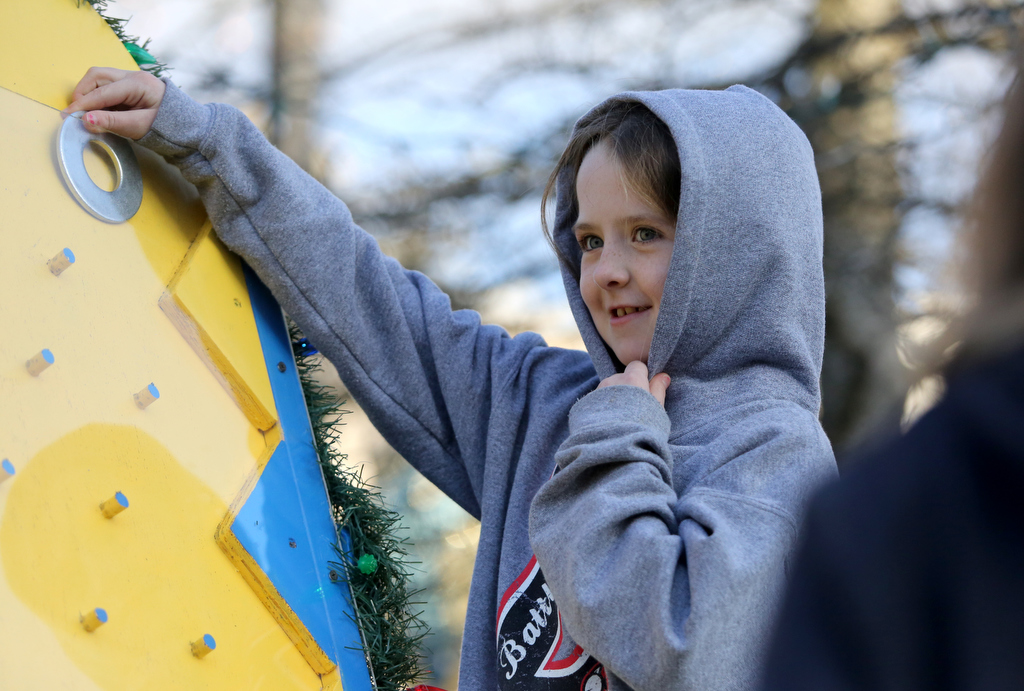 Staff photo by Erin O. Smith / Erin Anderson, 8, plays Plinko at the Cross Connection Assembly of God booth during the Christmas in the Streets Block Party Saturday, December 14, 2019 in Chickamauga, Georgia. At the bottom of the Plinko game, there was a chance of winning one or two pieces of candy.