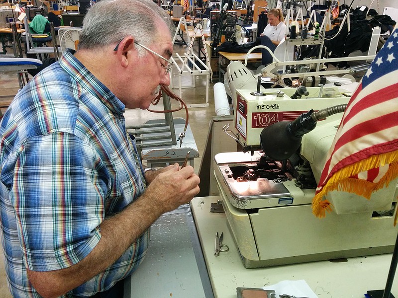 Staff Photo by Ellis Smith—Mechanic Jimmy Dunn works on a broken sewing machine at Cleveland, Tenn.-based Hardwick Clothes