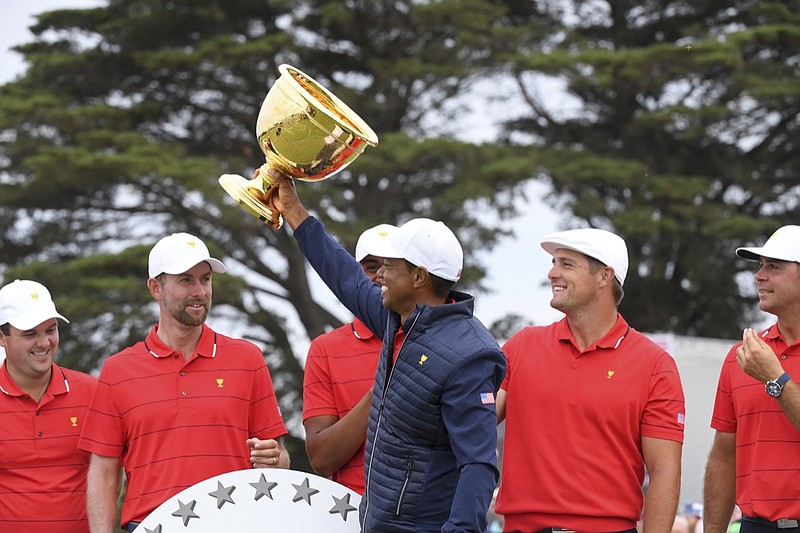 U.S. team player and captain Tiger Woods, center, holds up the trophy after the U.S. team won the President's Cup golf tournament at Royal Melbourne Golf Club in Melbourne, Sunday, Dec. 15, 2019. The U.S. team won the tournament 16-14. (AP Photo/Andy Brownbill)