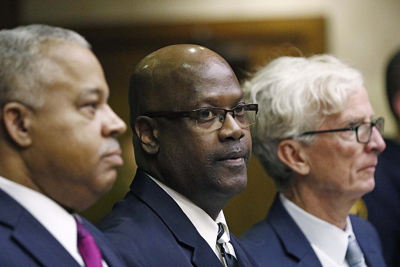 Defendant Curtis Flowers, center, stands with his attorneys, Henderson Hill, left, and Rob McDuff, at a bail hearing in Winona, Miss., Monday, Dec. 16, 2019. Flowers has been tried six times for murder in the 1996 shooting deaths of four people in a furniture store. Although sentenced to death during the sixth trial, the U.S. Supreme Court overturned that conviction in June, finding that prosecutors had shown a pattern of improperly excluding African American jurors in the trials of Flowers, who is black. Flowers was granted bail. (AP Photo/Rogelio V. Solis) ///

