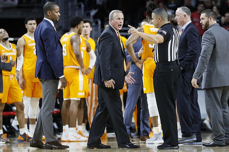 Tennessee men's basketball coach Rick Barnes, center, argues with an official about a call during the second half of the Vols' game Wednesday night at Cincinnati. Tennessee lost 78-66. / AP photo by John Minchillo