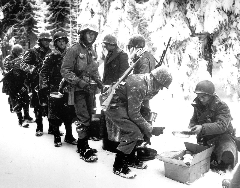 In this Jan. 13, 1945 file photo, and provided by the U.S. Army, American soldiers of the 347th U.S. Infantry wear heavy winter gear as they receive rations in La Roche, Belgium.It was 75 years ago that Hitler launched his last desperate attack to turn the tide for Germany in World War II. It was 75 years ago that Hitler launched his last desperate attack to turn the tide for Germany in World War II. At first, German forces drove so deep through the front line in Belgium and Luxembourg that the month-long fighting came to be known as The Battle of the Bulge. When the Germans asked one American commander to surrender, the famous reply came: "Nuts!" By Christmas, American troops had turned the tables on the Germans. Veterans are heading and on Monday, Dec. 16, 2019 when they will mix with royalty and dignitaries to mark perhaps the greatest battle in U.S. military history. (U.S. Army, via AP, File)