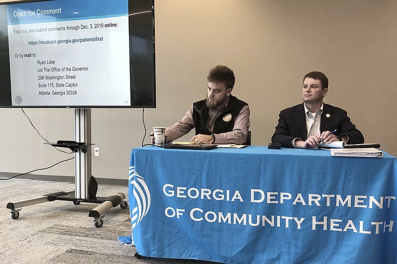 In this photo taken on Nov. 22, 2019, Ryan Loke, left, Gov. Brian Kemp's health policy adviser, and Blake Fulenwider, the chief health policy officer for the Georgia Department of Community Health, attend a public hearing in Kennesaw, Ga., about Kemp's recent health care proposals. Georgia could be the first state to test proposals from the Trump administration that would dramatically change the federal market for health insurance. (AP Photo/Sudhin Thanawala)