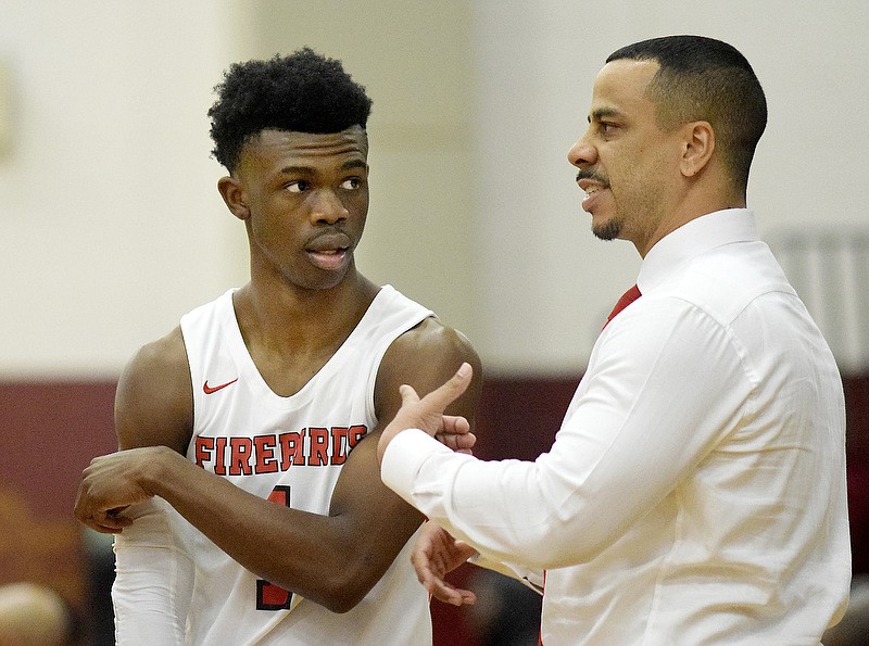 Pearl-Cohn's Marcus Fitzgerald listens as coach Terry Cole instructs the Firebirds during a timeout in their game against Tyner on Saturday night in the Henry Bowles Basketball Classic at Howard. / Staff photo by Robin Rudd