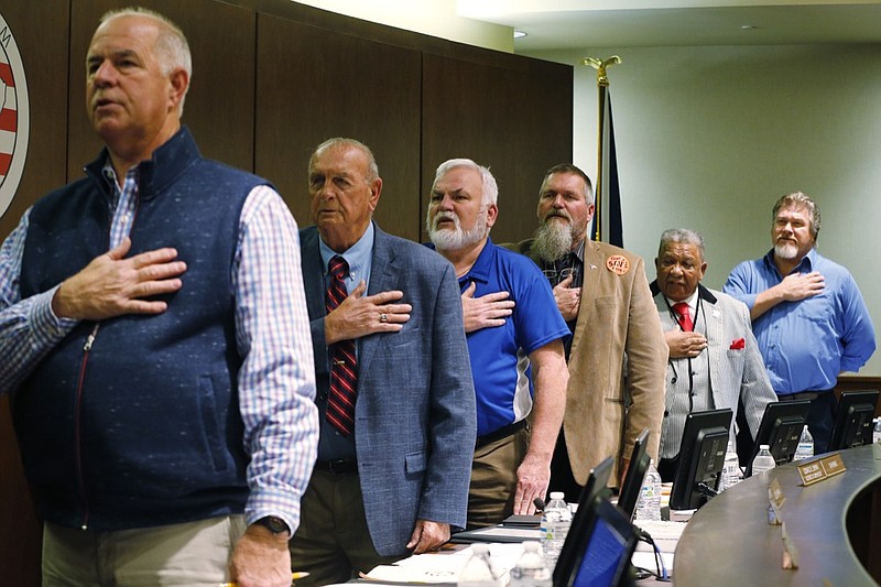Members of the Buckingham County Board of Supervisors, from left, Don Matthews, Harry Bryant, Donald Bryan, Morgan Dunnavant, Joe Chambers Jr., Danny Allen, pledge allegiance to the flag prior to voting to pass a Second Amendment Sanctuary City resolution at a meeting in Buckingham , Va., Monday, Dec. 9, 2019. The board voted unanimously to pass the resolution without public comment. (AP Photo/Steve Helber)
