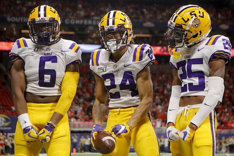 LSU linebacker Jacob Phillips (6) and cornerback Cordale Flott (25) celebrate with cornerback Derek Stingley Jr. after Stingley's interception in the second half of the SEC title game against Georgia at Mercedes-Benz Stadium on Dec. 7 in Atlanta. / Staff photo by C.B. Schmelter
