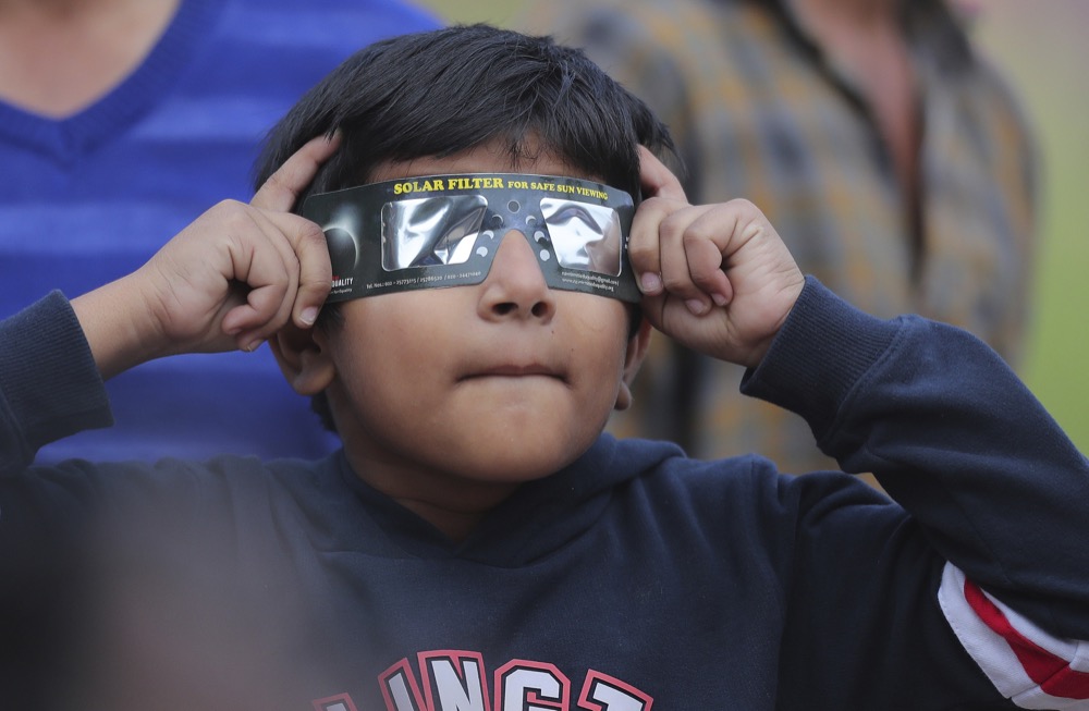 An Indian boy watch a partial solar eclipse in Hyderabad, India, Thursday, Dec. 26, 2019. The last solar eclipse of 2019 was witnessed in India along with several other countries. (AP Photo/Mahesh Kumar A.)