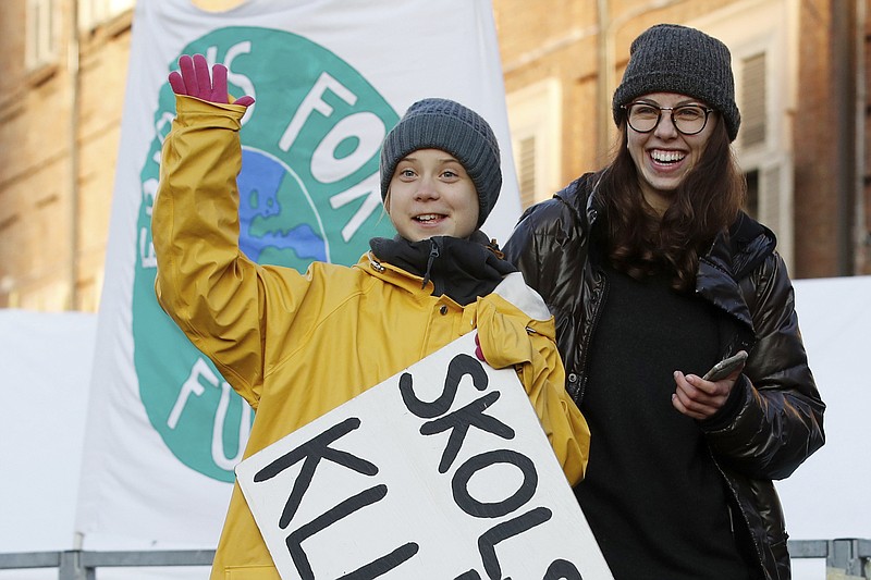 In this Friday. Dec. 13, 2019, file photo, Swedish environmental activist Greta Thunberg holds a sign with writing reading in Swedish, "School strike for the climate" as she attends a climate march, in Turin, Italy. (AP Photo/Antonio Calanni)