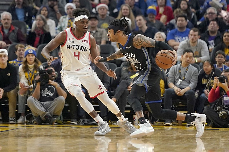 Golden State Warriors guard D'Angelo Russell (0) dribbles past Houston Rockets forward Danuel House Jr. (4) during the first half of an NBA basketball game in San Francisco, Wednesday, Dec. 25, 2019. (AP Photo/Tony Avelar)
