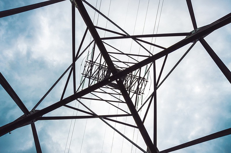 Electricity distribution tower with copy space. High voltage power lines under cloudy sky. Minimalist view from below on poles with wires at overcast weather. Atmospheric electrical background. - stock photo power line electric tile electricity tile power pole / Getty Images
