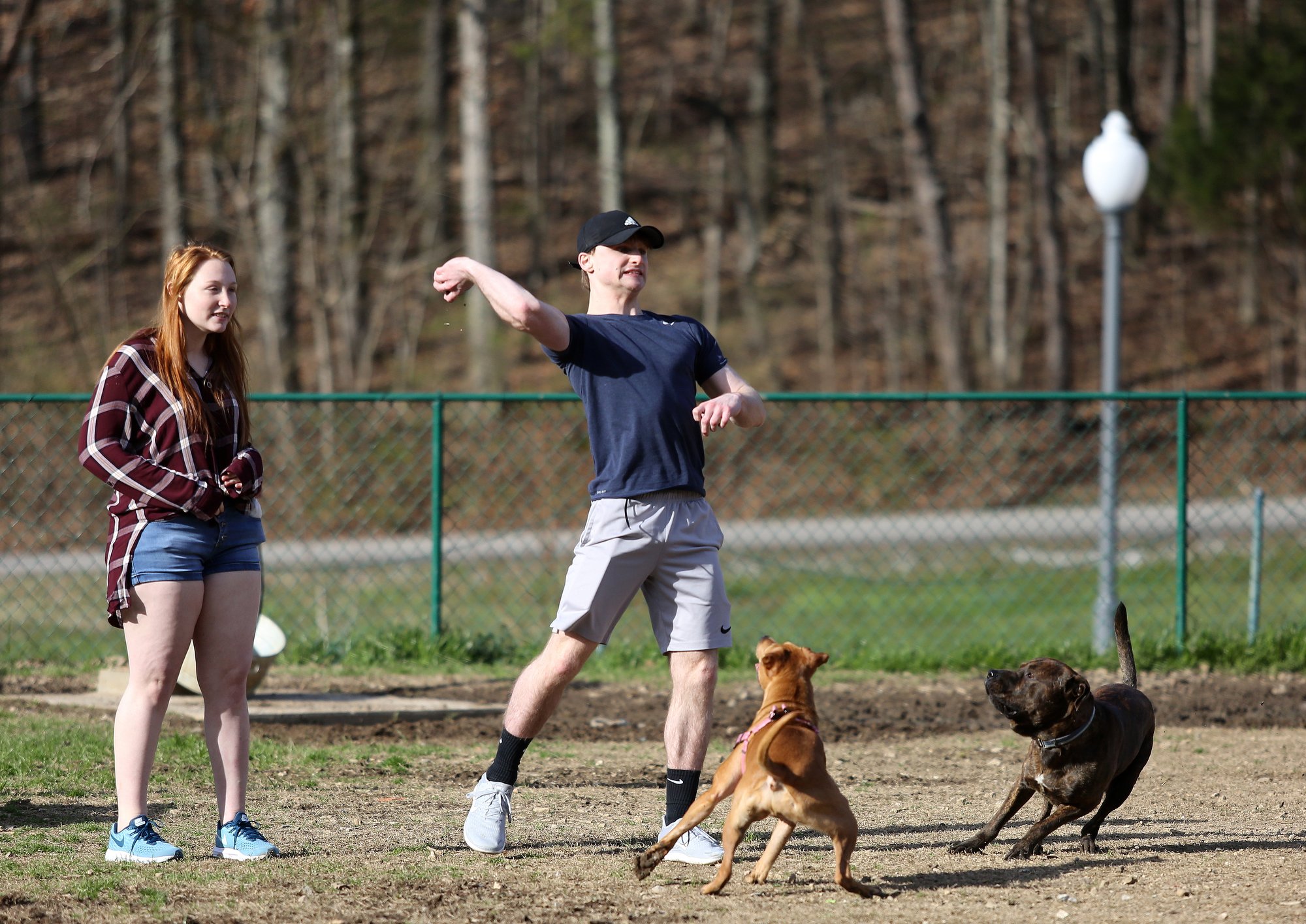 Elizabeth Woodall and Caelan Cline play with their dogs Goldie and Zeus Monday, February 25, 2019 at the Red Bank Dog Park in Red Bank, Tennessee. The two say they regularly brings their dogs to the dog park, but haven't been in a while due to all of the rain. / Staff photo by Erin O. Smith