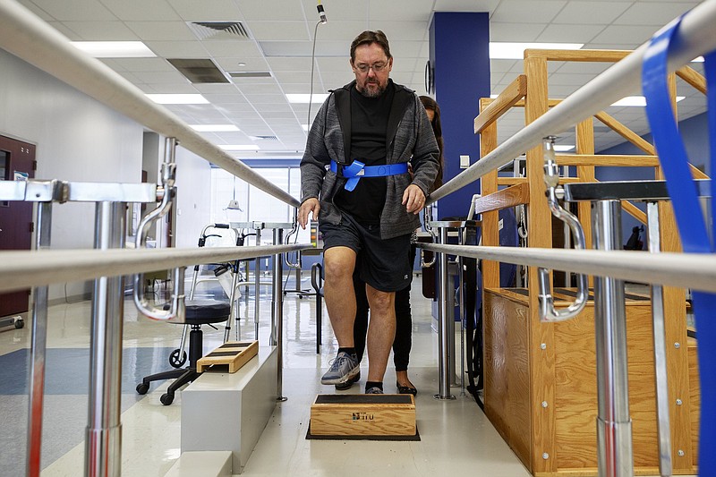 Staff photo by C.B. Schmelter / Physical Therapist Rebecca Weant, back, helps Kenny Fleshman during a physical therapy session at Siskin Hospital for Physical Rehabilitation on Wednesday, Oct. 9, 2019 in Chattanooga, Tenn. Fleshman is undergoing rehab for the neurological damage he incurred as a result of eastern equine encephalitis. He is the only known Tennessean to be diagnosed.