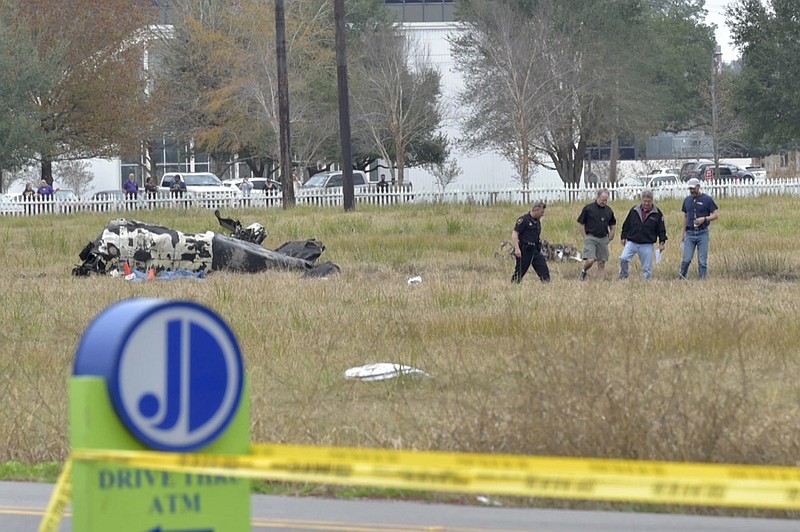 Investigators look over the site of a plane crash near Feu Follet Road and Verot School Road in Lafayette, La., Saturday, Dec. 28, 2019.  Authorities confirmed the accident but details on whether anyone was injured was not immediately known.(Scott Clause/The Lafayette Advertiser via AP)