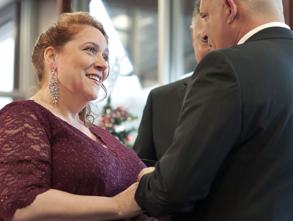 Bride Valerie Sneade places the ring on groom Jason Roy's finger during their wedding ceremony at the Dunkin' Donuts on Friday, Dec. 27, 2019 in Worcester, Mass. The couple reunited for their wedding vows at the Dunkin' Donuts where their young love splintered nearly thirty years ago. Except for a couple of chance encounters, Sneade and Roy mostly didn't see each other for 25 years after a conversation about their future at the same donut shop in 1992 led the young couple to slowly cut ties. Sneade and Roy blame misunderstandings at the time and words that didn't come out right. (Rick Cinclair/Worcester Telegram & Gazette via AP)