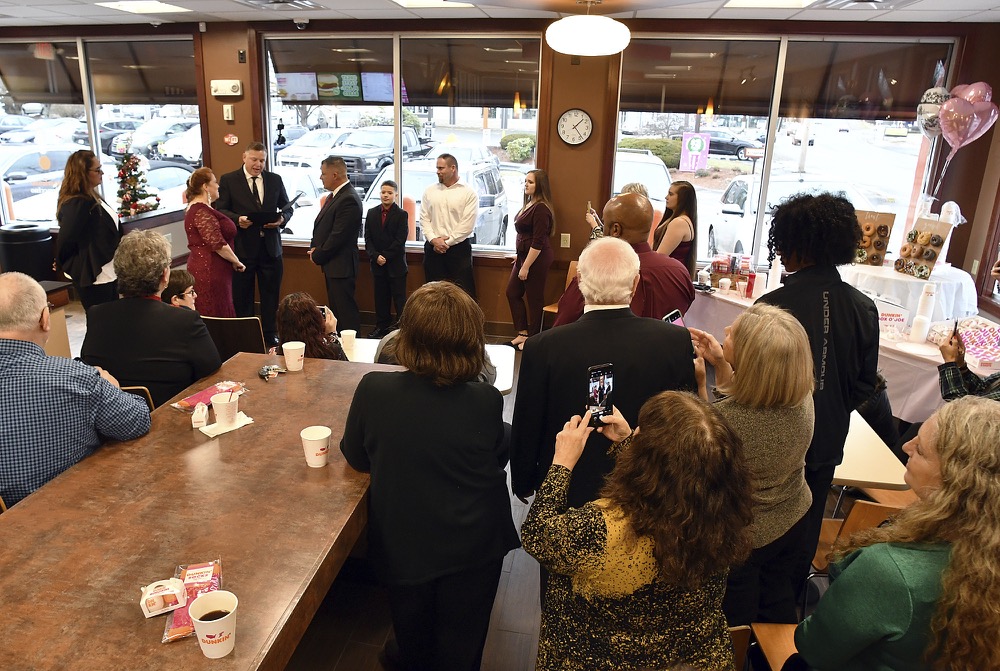 Jason Roy and Valerie Sneade say their vows in front of friends and family at the Dunkin' Donuts on Friday, Dec. 27, 2019 in Worcester, Mass. The couple reunited for their wedding vows at the Dunkin' Donuts where their young love splintered nearly thirty years ago. Except for a couple of chance encounters, Sneade and Roy mostly didn't see each other for 25 years after a conversation about their future at the same donut shop in 1992 led the young couple to slowly cut ties. Sneade and Roy blame misunderstandings at the time and words that didn't come out right. (Rick Cinclair/Worcester Telegram & Gazette via AP)