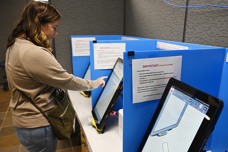 FILE- In this Nov. 5, 2019 file photo, Courtney Parker votes on a new voting machine, in Dallas, Ga. New voting machines that combine touchscreens with paper ballots are getting a limited test run in Georgia, as officials rush to meet a court-ordered deadline to retire the old system before any votes are cast in 2020. This was one of the top stories in Georgia in 2019.  (AP Photo/Mike Stewart, File)