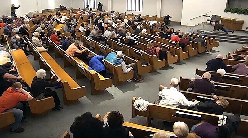 In this still frame from livestreamed video provided by law enforcement, churchgoers take cover while a congregant armed with a handgun, top left, engages a man who opened fire, near top center just right of windows, during a service at West Freeway Church of Christ, Sunday, Dec. 29, 2019, in White Settlement, Texas. The footage was broadcast online by the church according to a law enforcement official, who provided the image to The Associated Press on condition on anonymity because the investigation is ongoing. (West Freeway Church of Christ/Courtesy of Law Enforcement via AP)