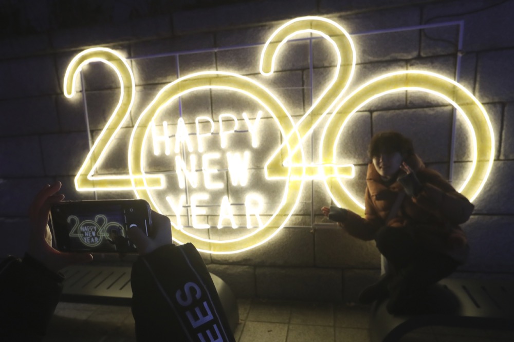 A woman poses for photos to celebrate the upcoming New Year in Seoul, South Korea, Tuesday, Dec. 31, 2019. (AP Photo/Ahn Young-joon)