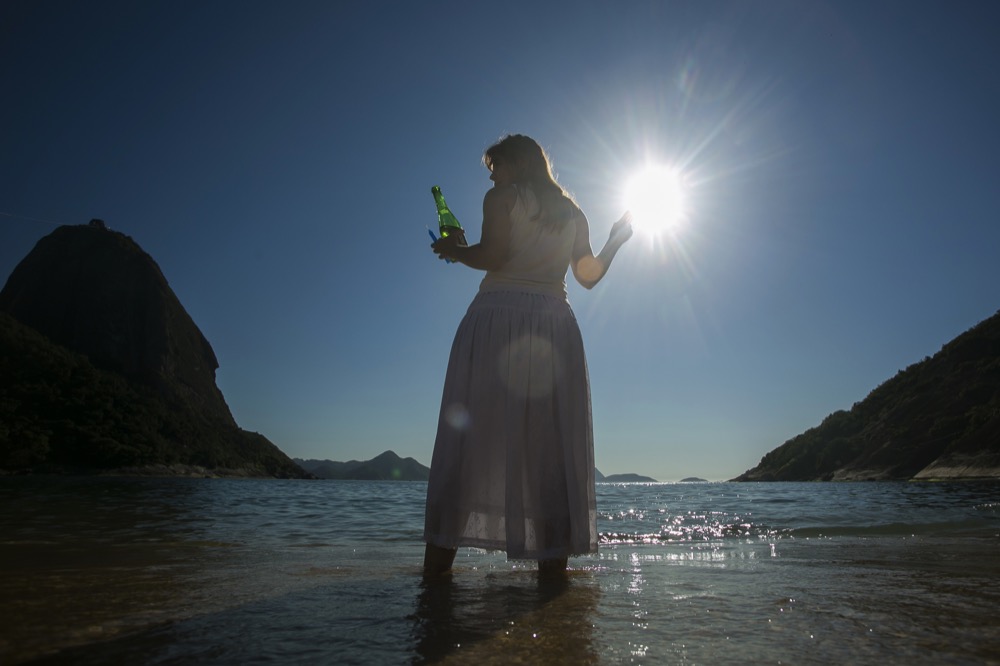 A woman holds a bottle of sparkling cider as an offering to Yemanja, a deity from the African Yoruba religion, during a ceremony in honor of the goddess of the sea, which is part of New Year celebrations on Praia Vermelha beach in Rio de Janeiro, Brazil, Tuesday, Dec. 31, 2019. As the year winds down, Brazilian worshippers of Yemanja celebrate the deity and ask for blessings for the coming year. (AP Photo/Bruna Prado)