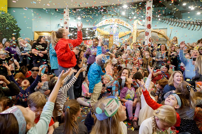 Staff photo by C.B. Schmelter / Attendees reach upwards as confetti falls during New Year's at Noon at the Creative Discovery Museum on Tuesday, Dec. 31, 2019 in Chattanooga, Tenn. The annual event is held specifically for children to celebrate the New Year with events like a confetti drop and an appearance by Father Time.