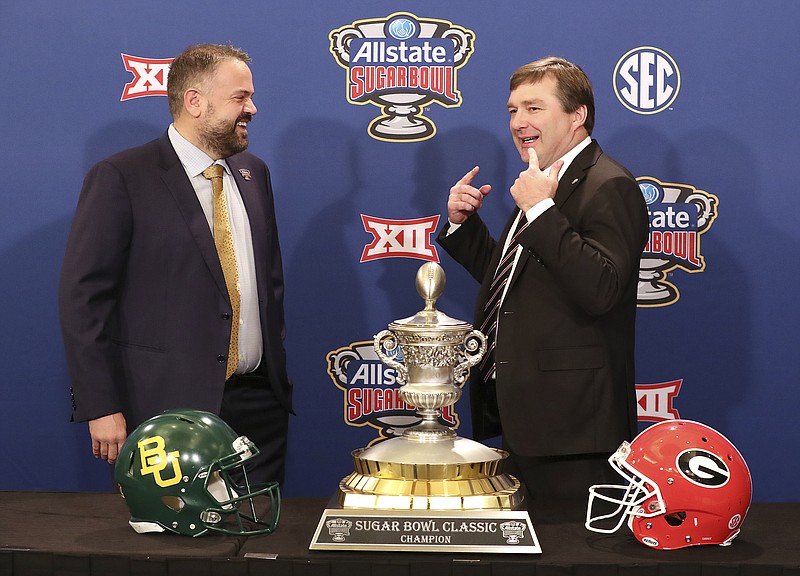 Georgia head coach Kirby Smart, right, tells Baylor head coach Matt Rhule you have to remember to smile during their photo opportunity with the Sugar Bowl trophy during an during an NCAA college football press conference, Tuesday, Dec. 31, 2019, in New Orleans. (Curtis Compton/Atlanta Journal-Constitution via AP)