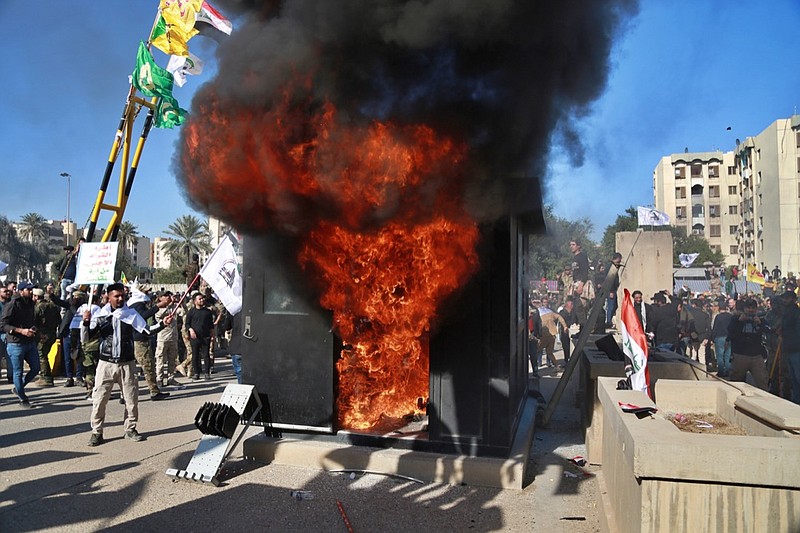 Protesters burn property in front of the U.S. embassy compound, in Baghdad, Iraq, Tuesday, Dec. 31, 2019. Dozens of angry Iraqi Shiite militia supporters broke into the U.S. Embassy compound in Baghdad on Tuesday after smashing a main door and setting fire to a reception area, prompting tear gas and sounds of gunfire. (AP Photo/Khalid Mohammed)
