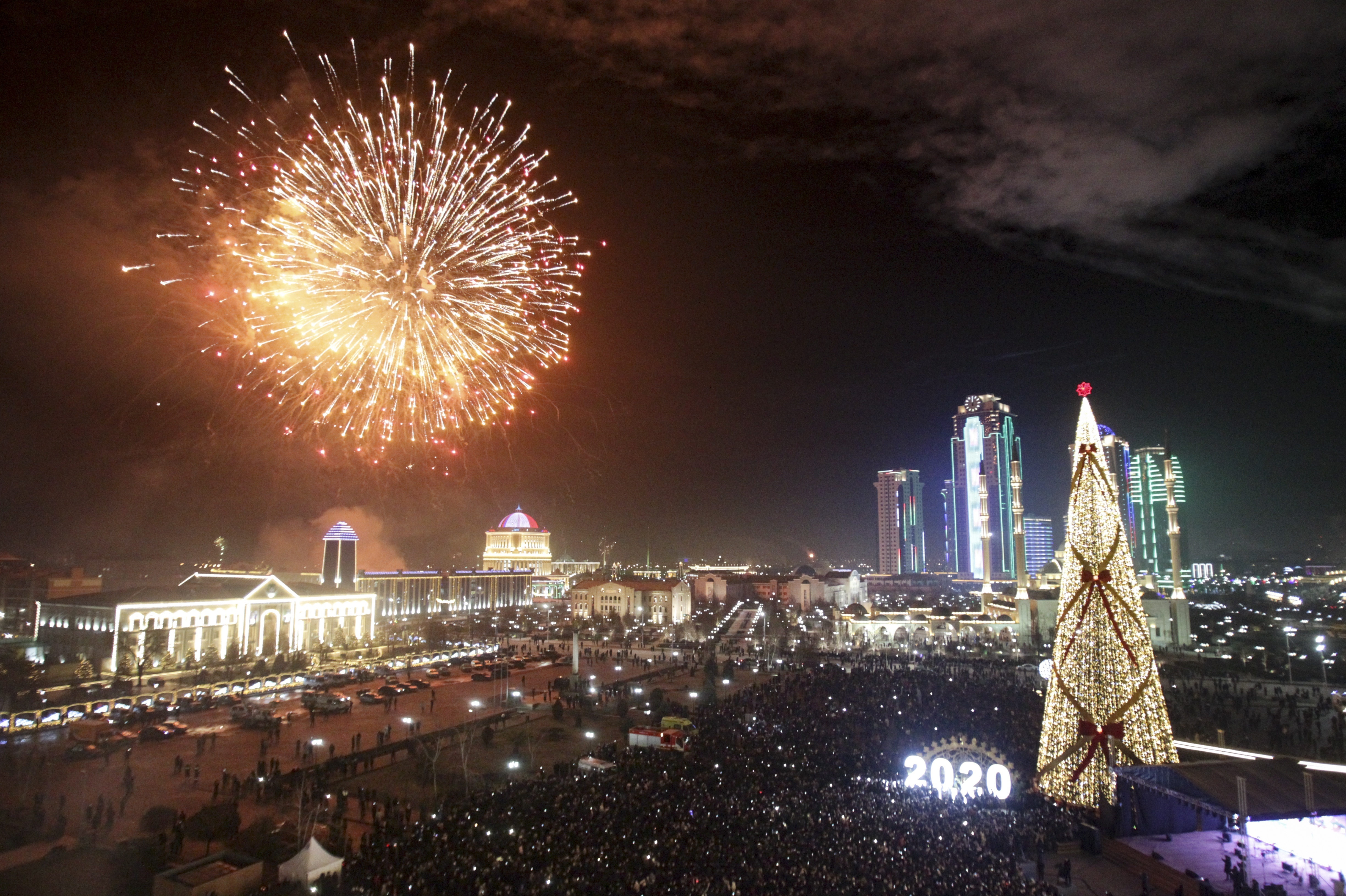 Fireworks explode over a Christmas tree and skyscrapers during New Year's celebrations in Grozny, Russia, Wednesday, Jan. 1, 2020. Russians began the world's longest continuous New Year's Eve with fireworks and a message from President Vladimir Putin urging them to work together in the coming year. (AP Photo/Musa Sadulayev)