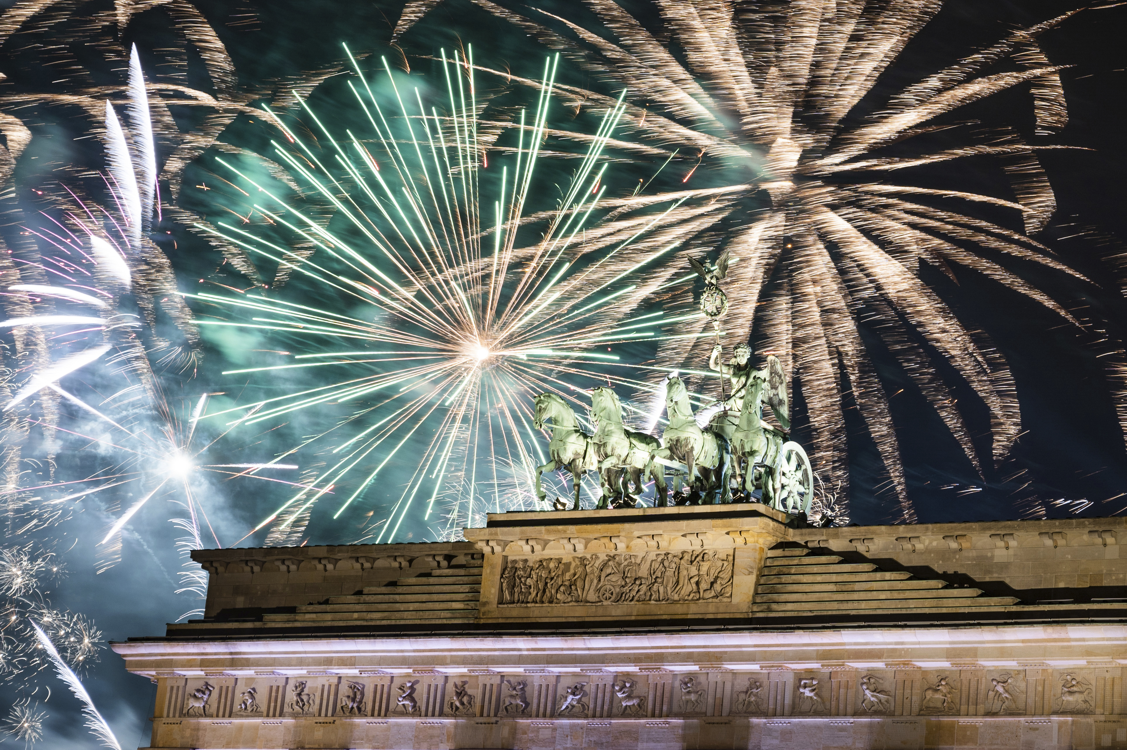 Fireworks light the sky above the Quadriga at the Brandenburg Gate during New Year celebrations in Berlin, Germany, Wednesday, Jan. 1, 2020. Hundred thousands of people celebrated New Year's Eve welcoming the new year 2020 in Germany's capital. (Christophe Gateau/dpa via AP)